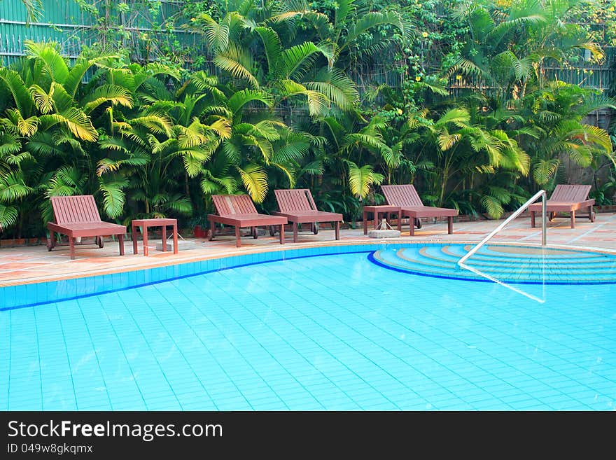 Wooden pool trestle beds by the resort poolside. Wooden pool trestle beds by the resort poolside