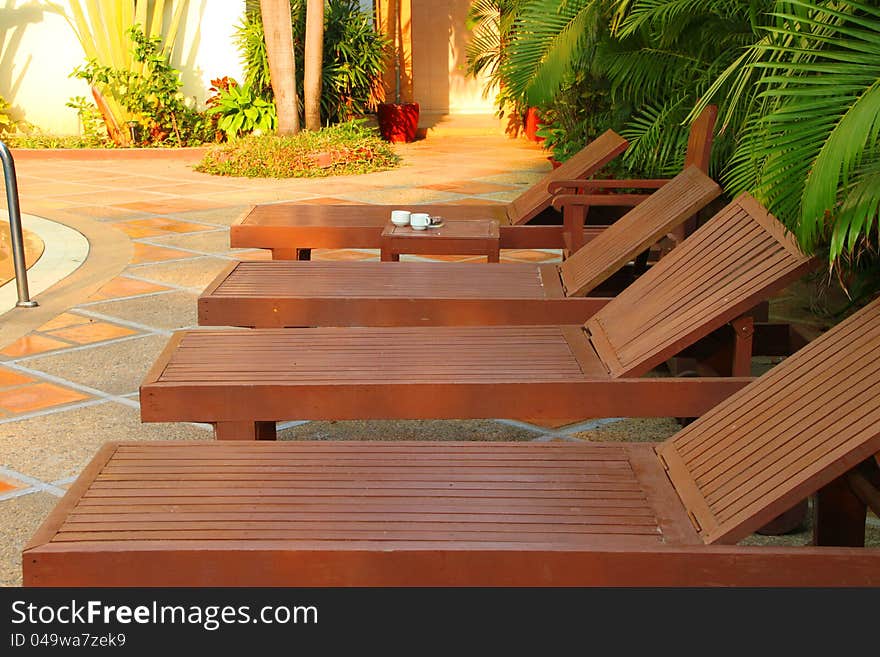 Wooden pool trestle beds by the resort poolside. Wooden pool trestle beds by the resort poolside