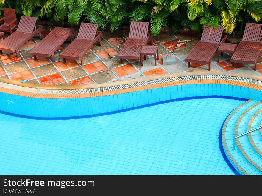 Wooden pool trestle beds by the resort poolside. Wooden pool trestle beds by the resort poolside