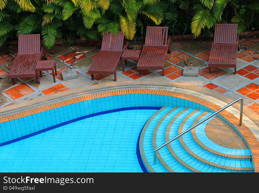 Wooden pool trestle beds by the resort poolside. Wooden pool trestle beds by the resort poolside