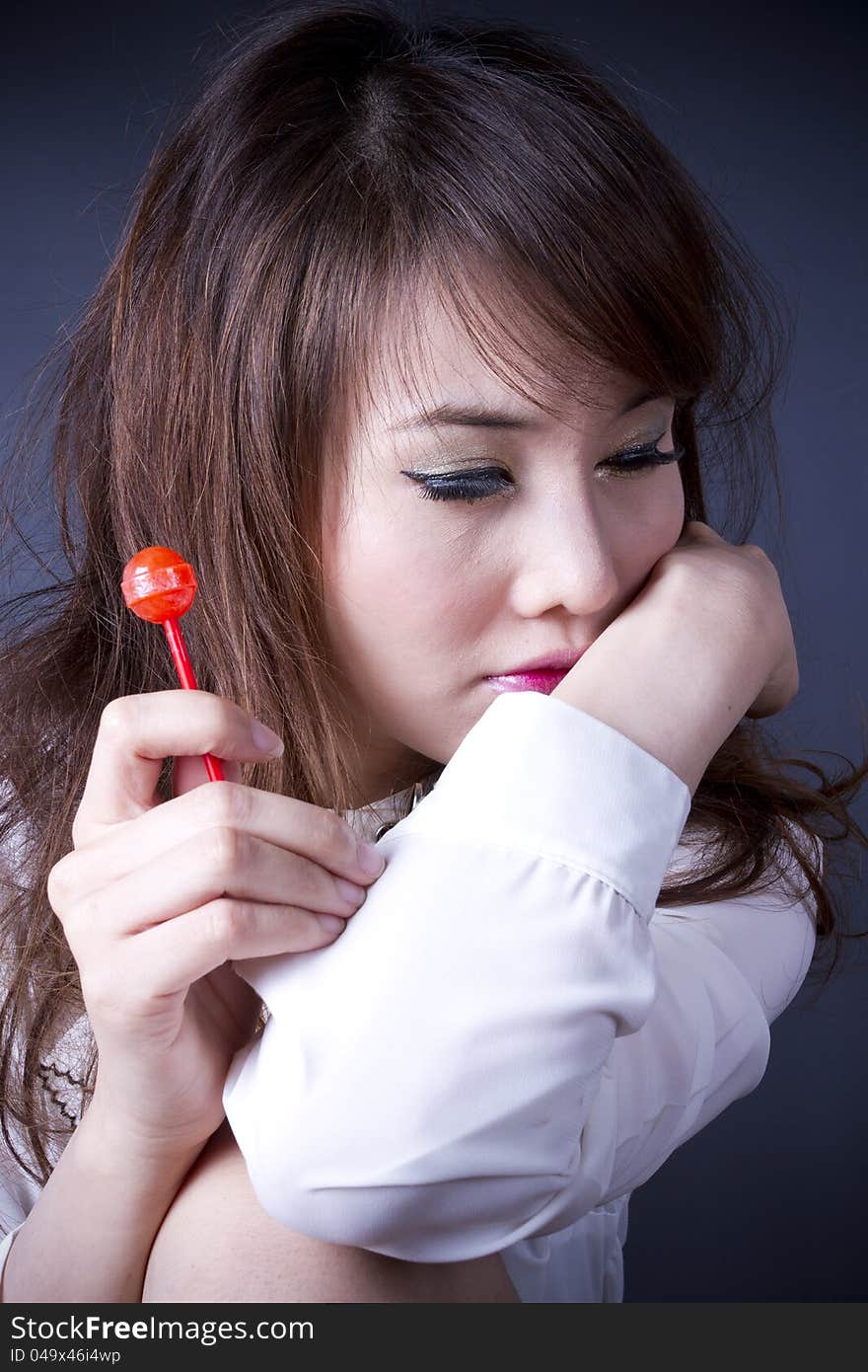 Female model pose cute action with red candy. Female model pose cute action with red candy.