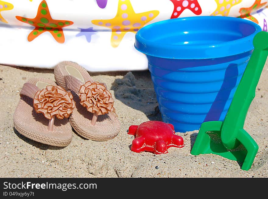 Children beach toys, bucket, spade and shovel on sand on a sunny day