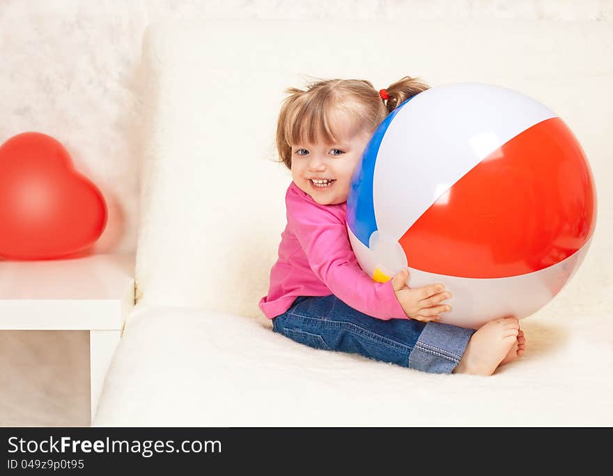 Portrait of a beautiful little girl holding a ball