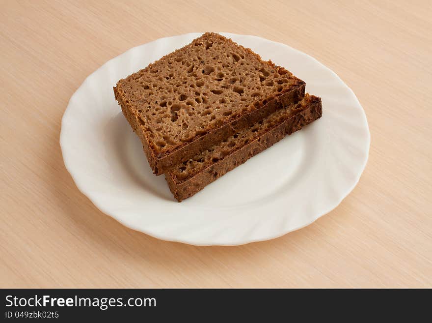 Two peaces of handmade black bread on plate