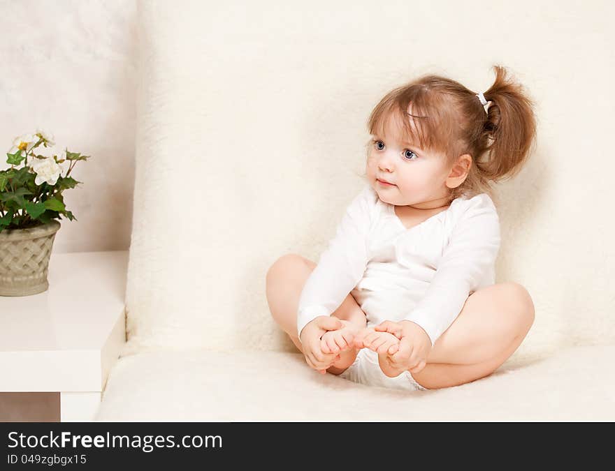 Photo Beautiful little girl sitting on the couch