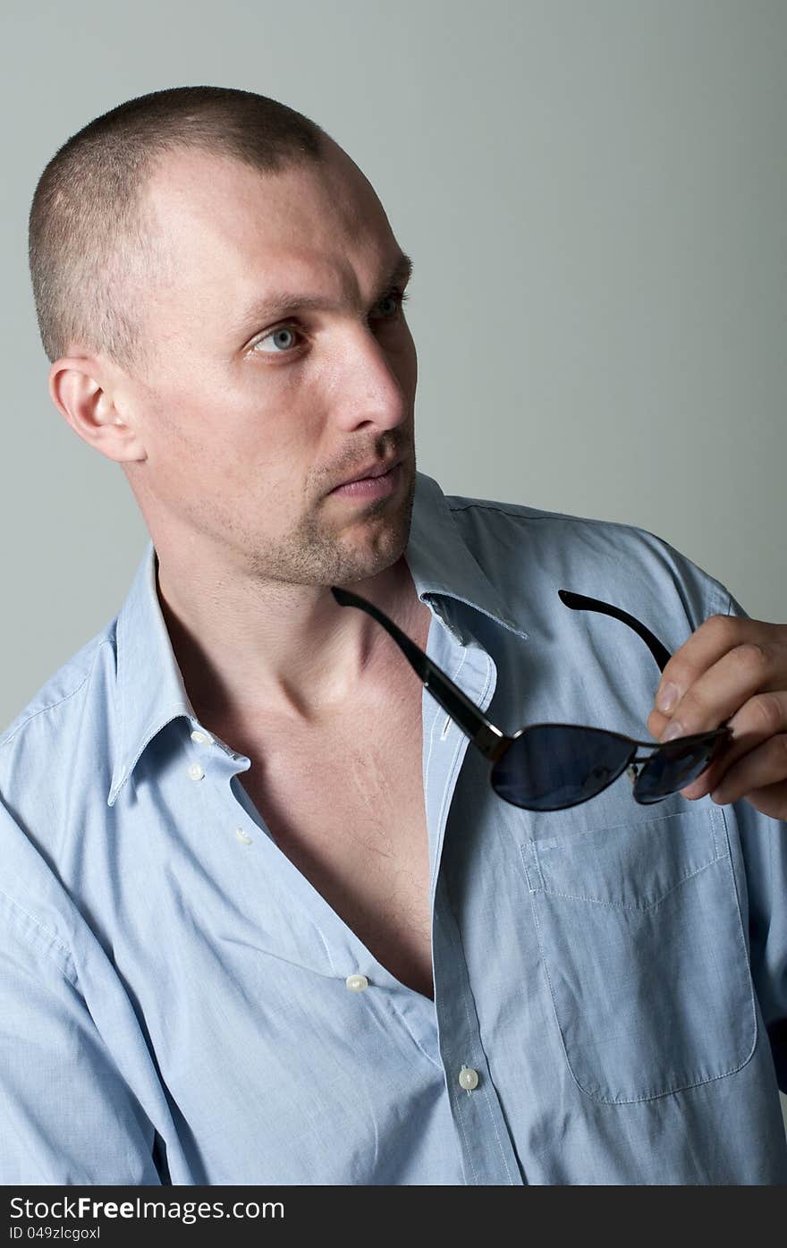 Serious young man in sunglasses in the studio