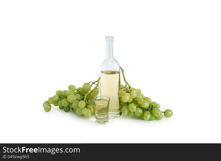 Open bottle of Italian vodka �grappa� near wineglass and bunch of grapes on white background. Clipping path is included. Open bottle of Italian vodka �grappa� near wineglass and bunch of grapes on white background. Clipping path is included