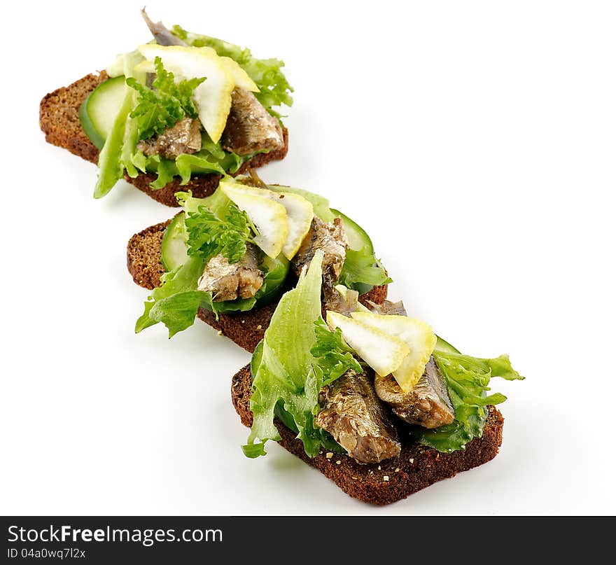 Three smoked sardines sandwiches with cucumber and whole wheat bread isolated on white background