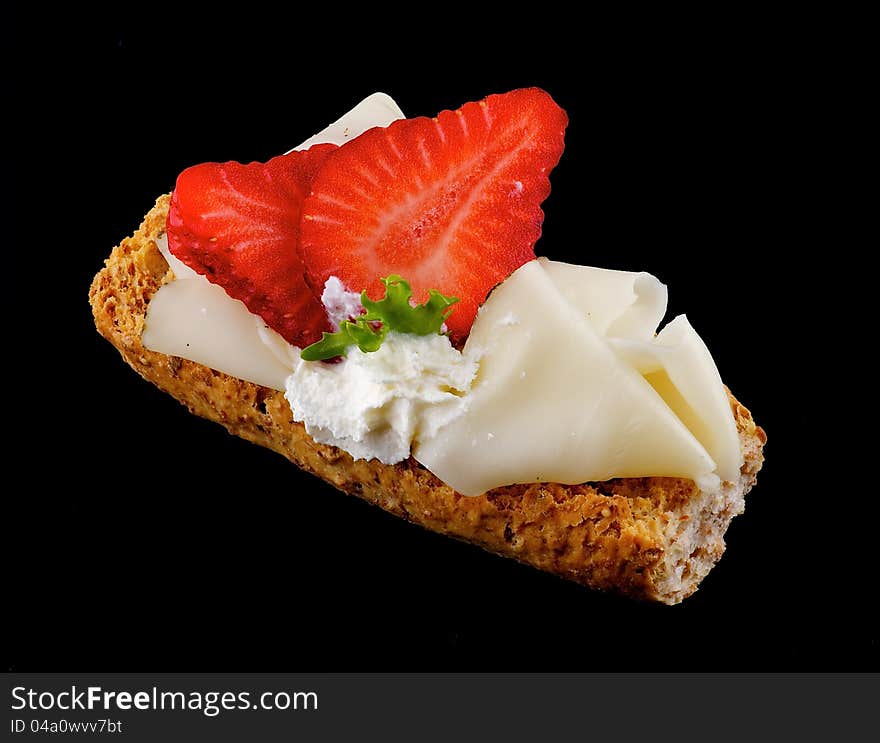 CreaspBread sandwich with cheese and strawberry isolated on black background