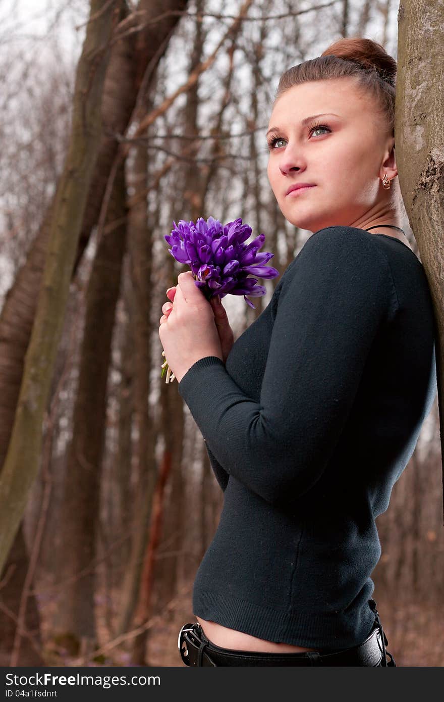 Beautiful girl with snowdrops in a forest