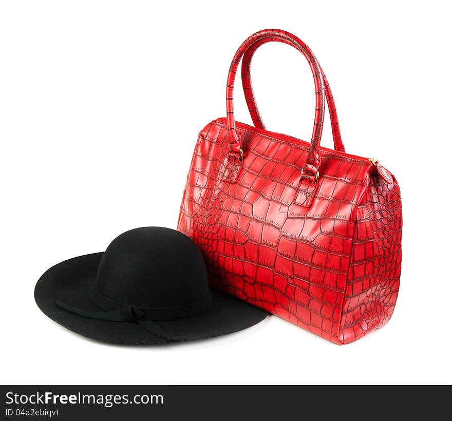 Red Fashion ladies handbag and a black felt hat in the studio on a white background