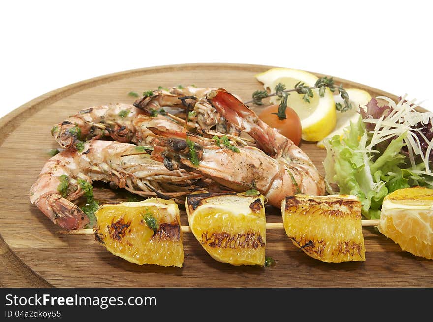 Grilled Shrimp with Orange on a wooden plate