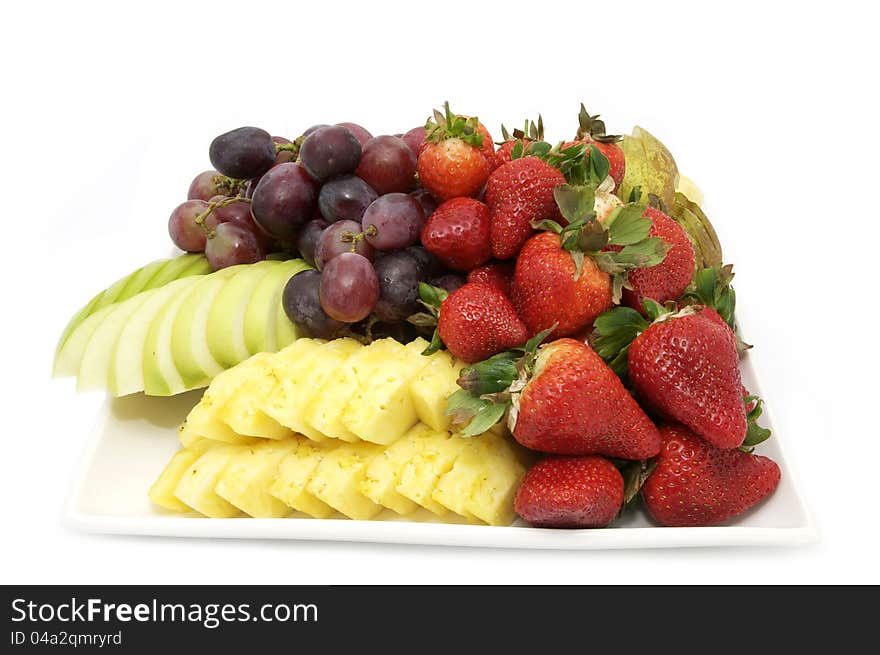 A plate of fresh fruit at a restaurant on a white background. A plate of fresh fruit at a restaurant on a white background