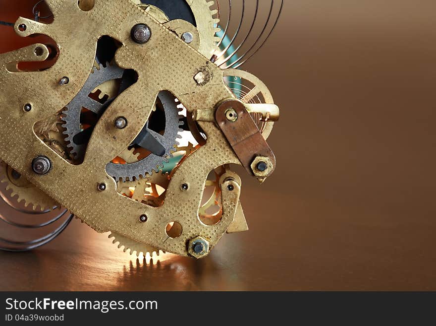 Closeup of old clock mechanism on brown background with free space for text. Closeup of old clock mechanism on brown background with free space for text