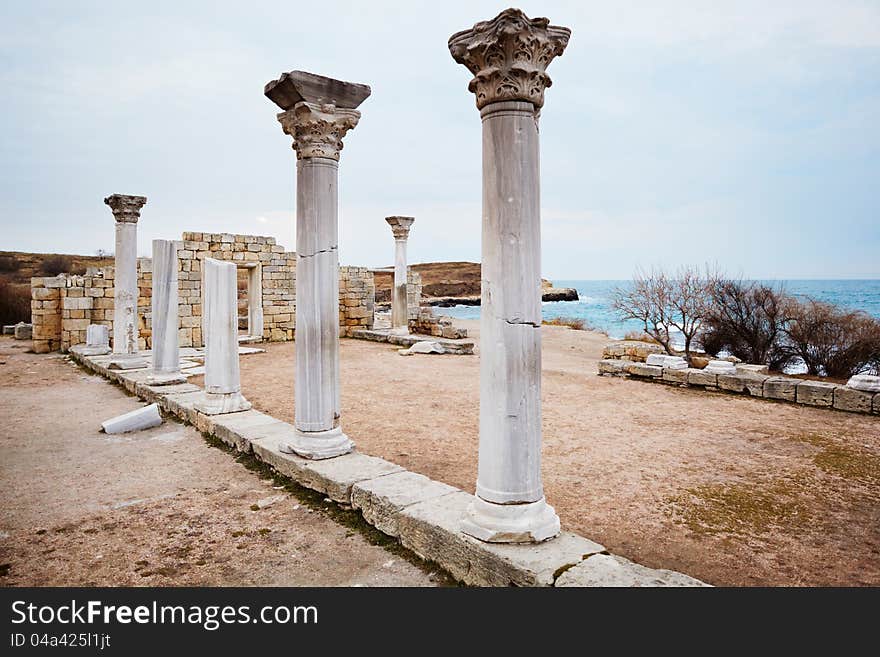 Row of ruined ancient column with the sea at the background. Khersones. Crimea. Ukraine. Row of ruined ancient column with the sea at the background. Khersones. Crimea. Ukraine