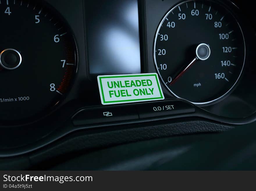 A sign on a vehicle dashboard indicating that only unleaded fuel can be used. A sign on a vehicle dashboard indicating that only unleaded fuel can be used