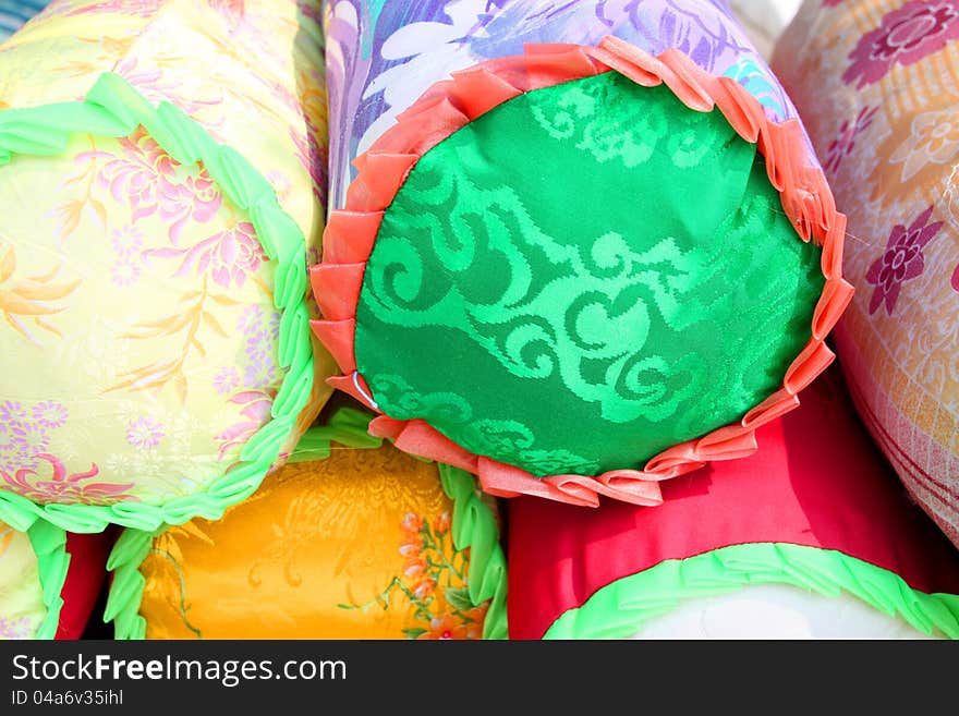 Pile of colorful bolsters for sale in market