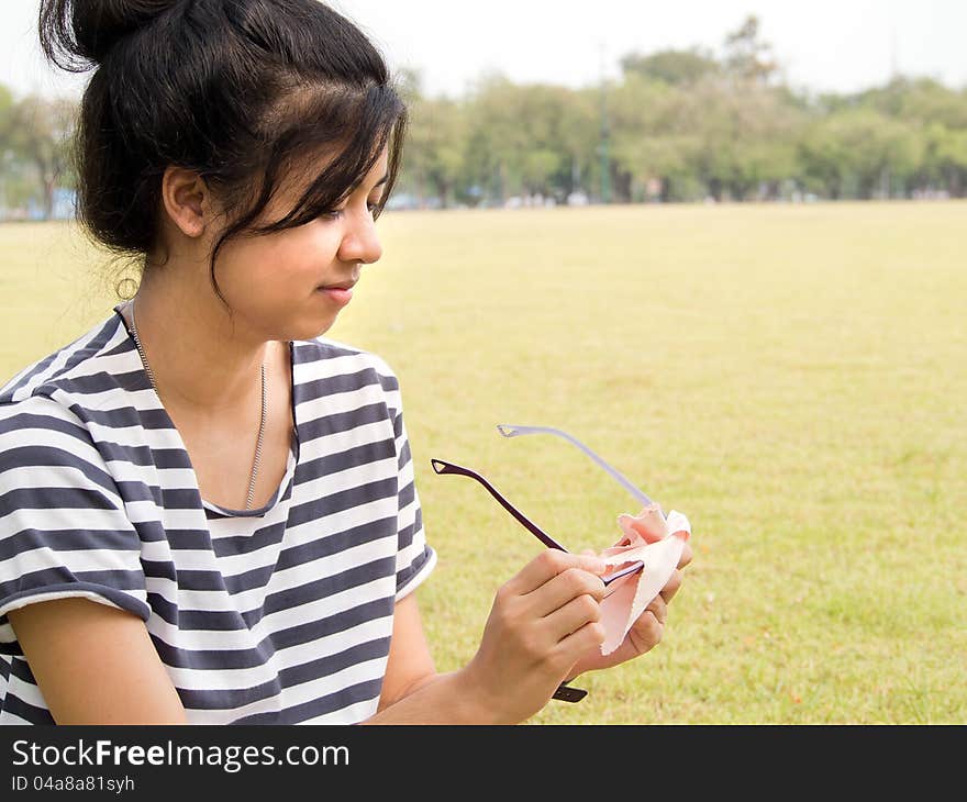 Girl cleaning her glasses