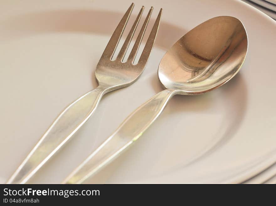 Close-up of spoon and fork on white dish