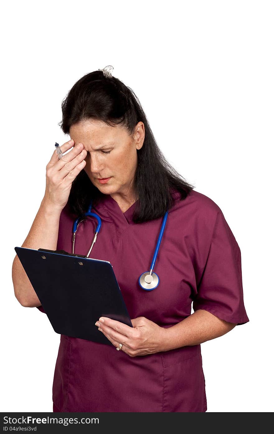 Mature female healthcare worker too tired to think. Wearing burgundy scrubs with blue stethoscope and isolated on a white background. Mature female healthcare worker too tired to think. Wearing burgundy scrubs with blue stethoscope and isolated on a white background.