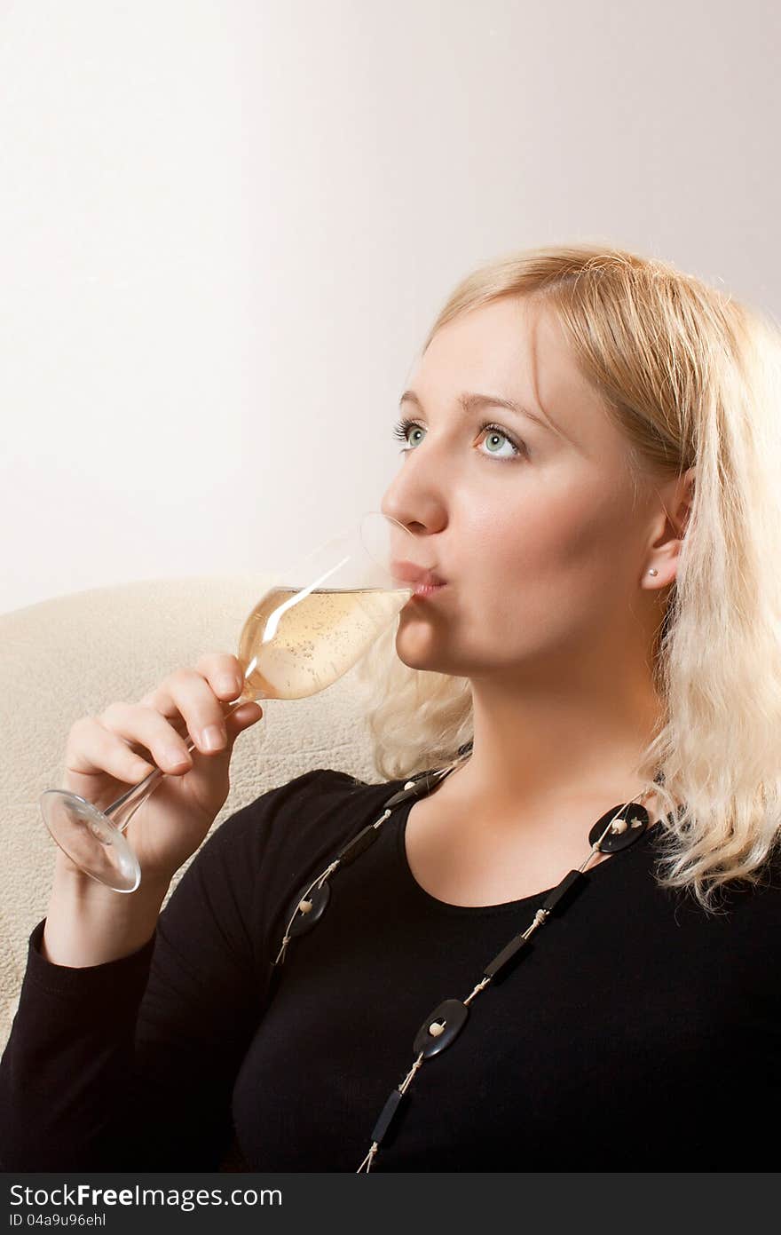 Young beautiful woman drinks wine from wine glass