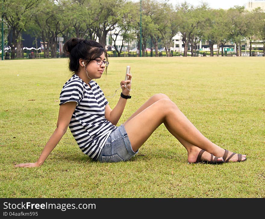 Woman relaxing and listening to music outdoors