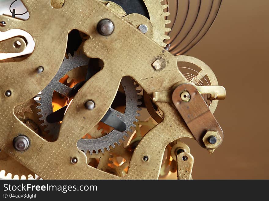 Closeup of old clock mechanism on brown background. Closeup of old clock mechanism on brown background