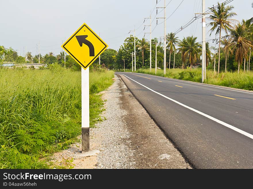 Curved road to the left signpost, asphalt road background. Curved road to the left signpost, asphalt road background