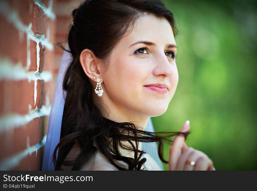 Happy bride in wedding walk neear red brick wall