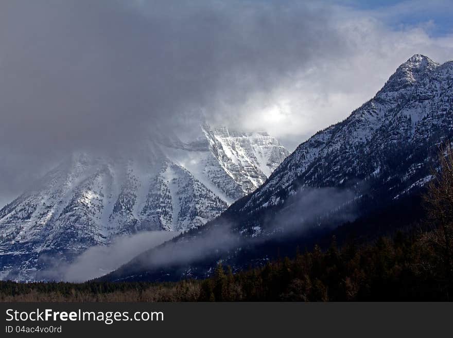 This image of the rugged snowy mountains with the storm clouds moving in was taken in Glacier National Park, MT. This image of the rugged snowy mountains with the storm clouds moving in was taken in Glacier National Park, MT.