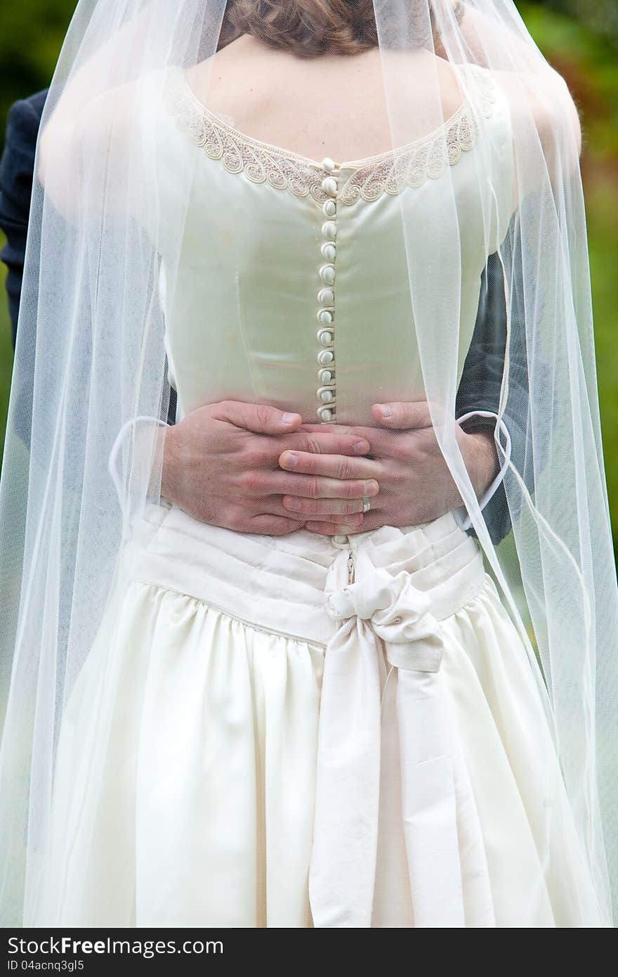 A groom is holding his bride, she is wearing a white dress. A groom is holding his bride, she is wearing a white dress