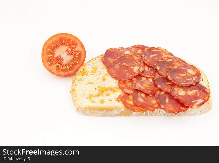 Bread with tomato and sausage ??Iberico on a white background