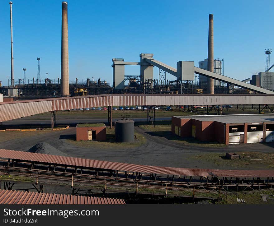 Industrial chimneys and conveyor belts in a coke manufacturing plant. Industrial chimneys and conveyor belts in a coke manufacturing plant.