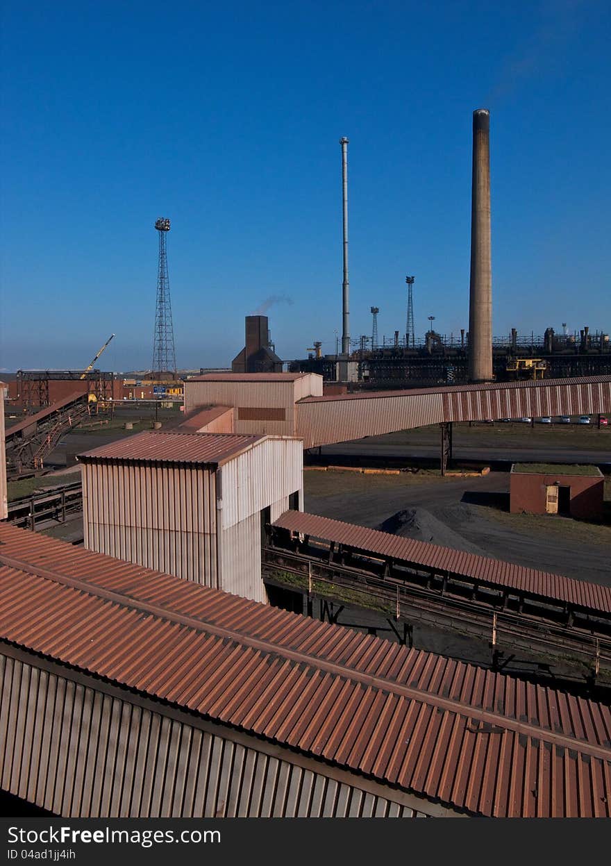 Industrial chimneys and conveyors in a coke manufacturing plant. Industrial chimneys and conveyors in a coke manufacturing plant.