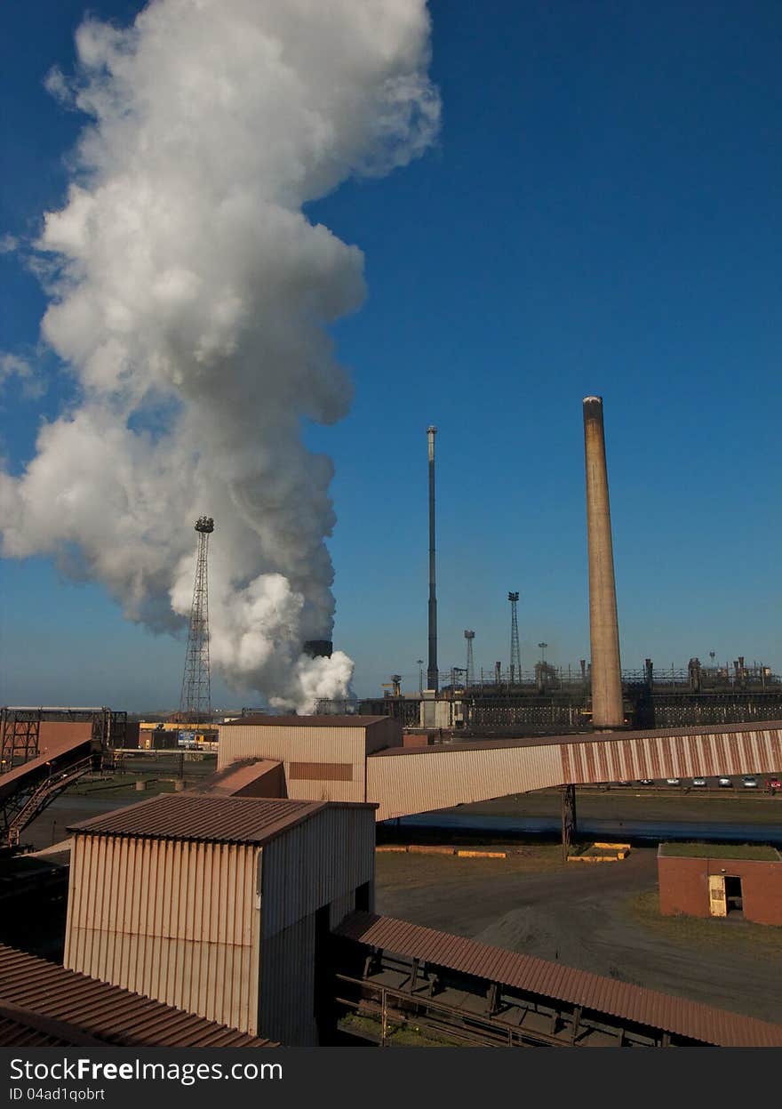 Industrial chimneys billowing steam into the blue sky. Industrial chimneys billowing steam into the blue sky