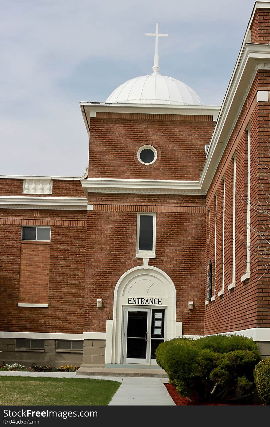 Image of a orange brick church building with a cross on top. Image of a orange brick church building with a cross on top