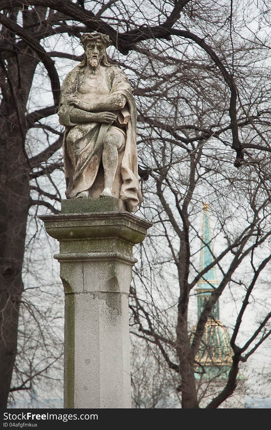 Ancient statue on a pillar, tower of St Martin Cathedral in background. photo in Bratislava Castle park, Slovakia. Ancient statue on a pillar, tower of St Martin Cathedral in background. photo in Bratislava Castle park, Slovakia.