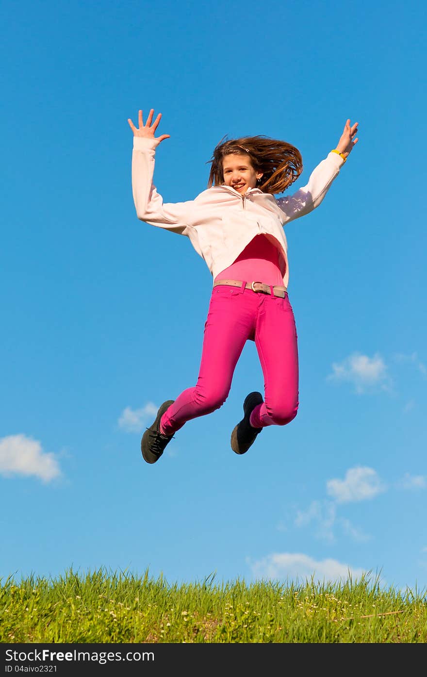 Cute teenage girl jumping with joy on sunny spring day.