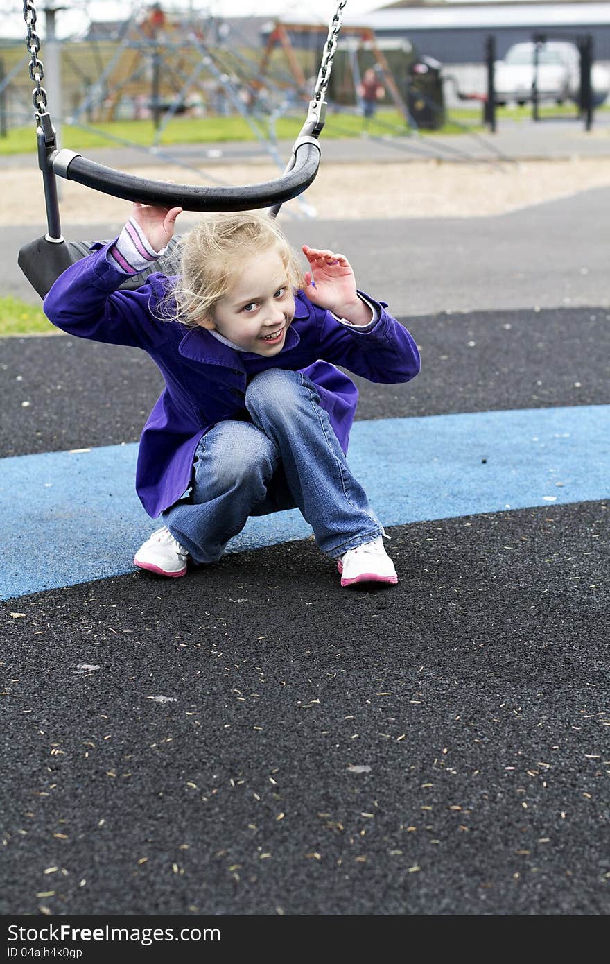 Young girl getting out of the swing. Young girl getting out of the swing