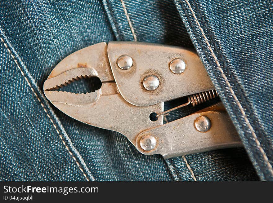 Old lock pliers in jeans pocket. Old lock pliers in jeans pocket