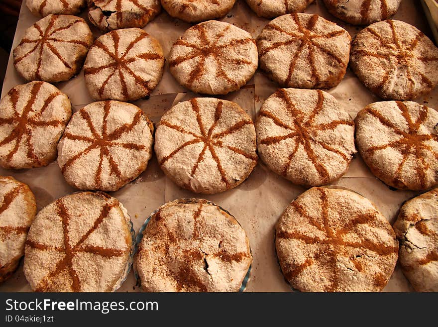 M’hancha – coiled serpent cake – Flat round of baked almond stuffed pastry coated with icing suger and cinnamon. M’hancha – coiled serpent cake – Flat round of baked almond stuffed pastry coated with icing suger and cinnamon