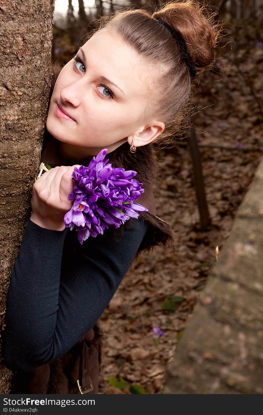 Beautiful girl with snowdrops in a forest