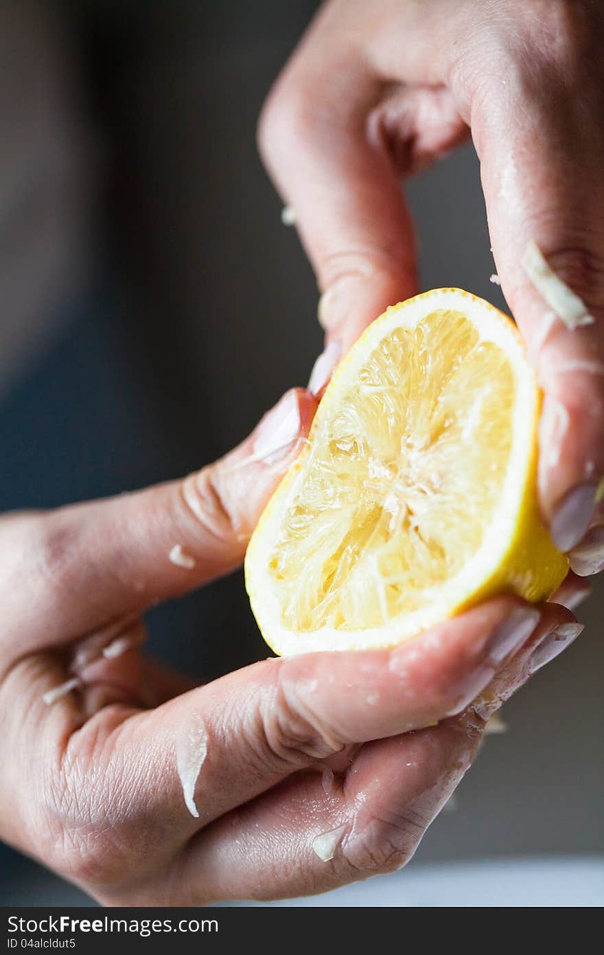 Hand squeezing yellow lemon closeup