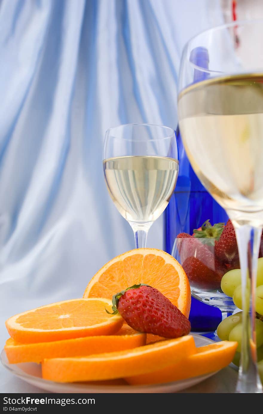 Clouseup of two glasses of wine with oranges and strawberry