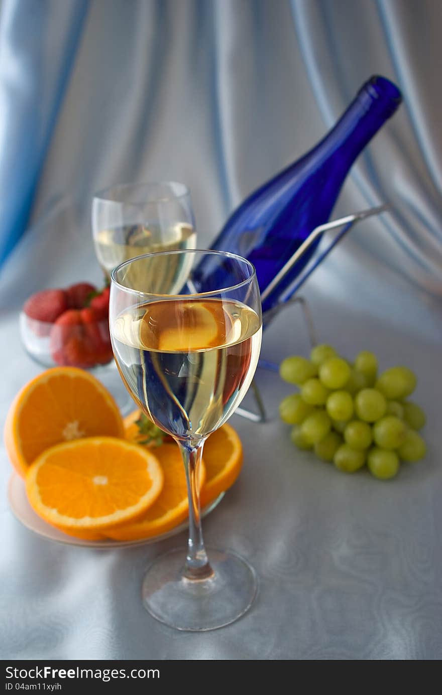 Glasses of wine with oranges and grapes