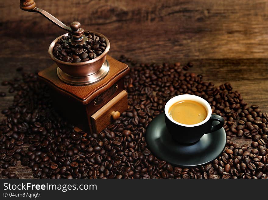 Mage of roasted coffee beans, coffee cup, and ground beans on a wooden table. Mage of roasted coffee beans, coffee cup, and ground beans on a wooden table.