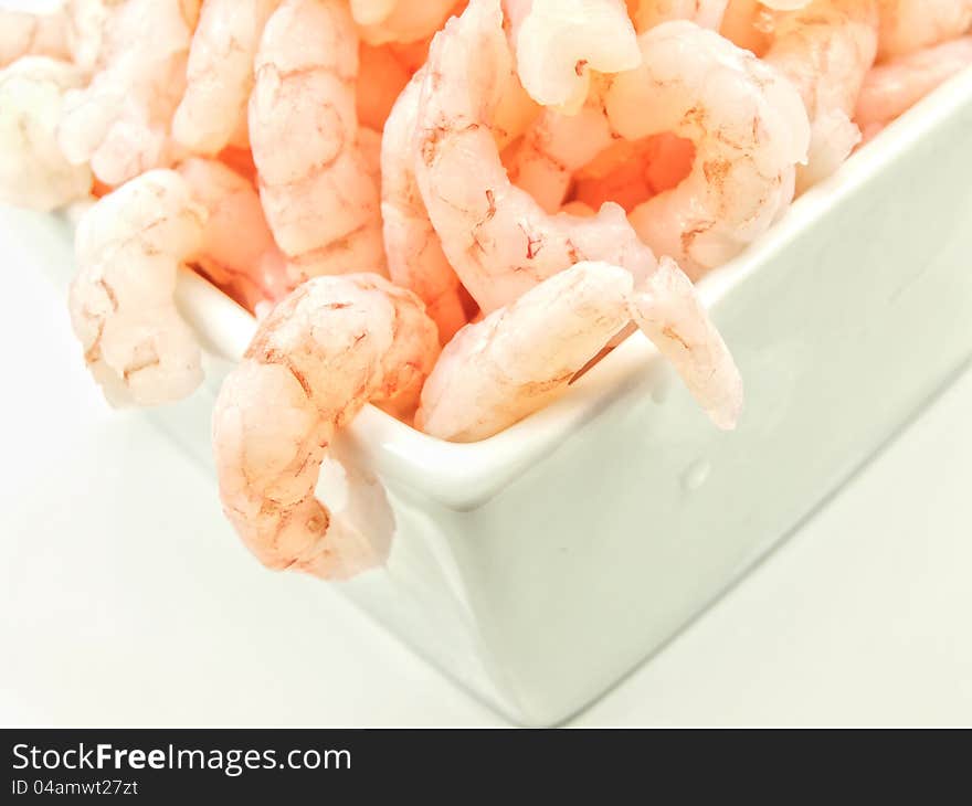 Peeled shrimps, close up, isolated in a white bowl