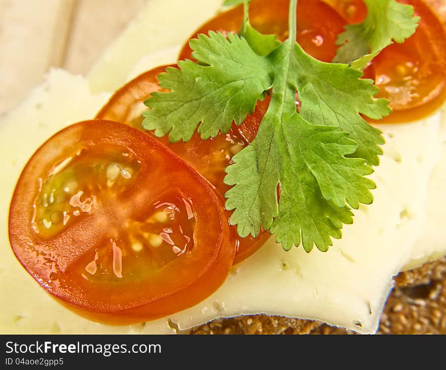 Cracker isolated on wooden plate, with cheese, tomato and parsley. Cracker isolated on wooden plate, with cheese, tomato and parsley