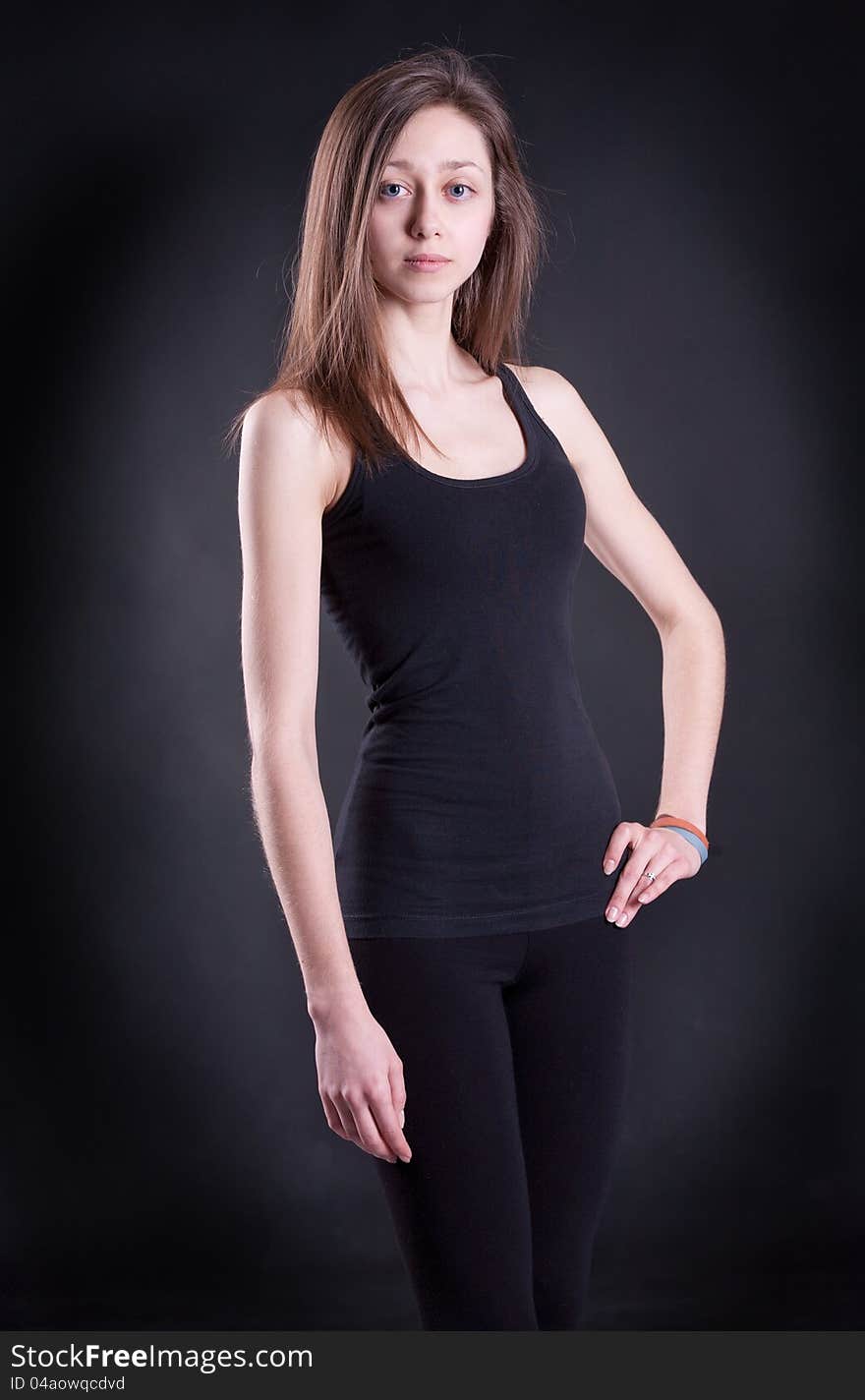 The girl in a black vest on a black background