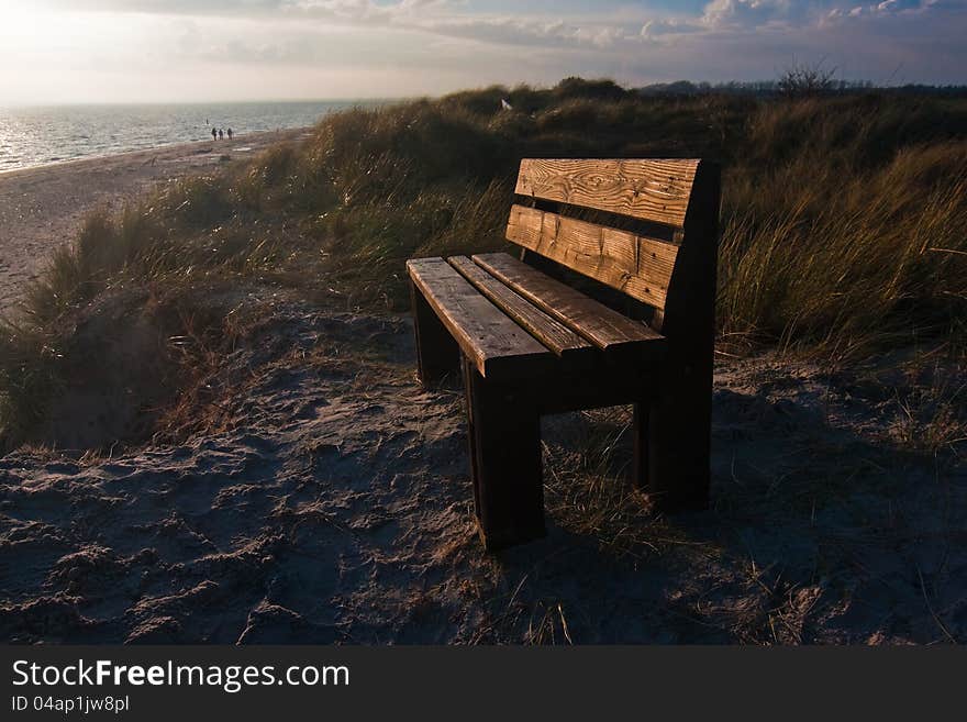 Bench on a dune with view on the Northern Sea in the background during sunset. The picture was taken on the Isle of Föhr in Northern Germany